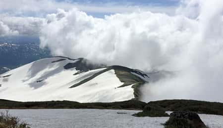 Descending the mountain at a fast pace to avoid being engulfed by clouds and fog